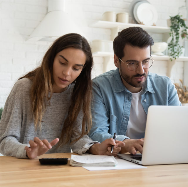 Image showing a couple at a table with a laptop and a calculator, making plans together